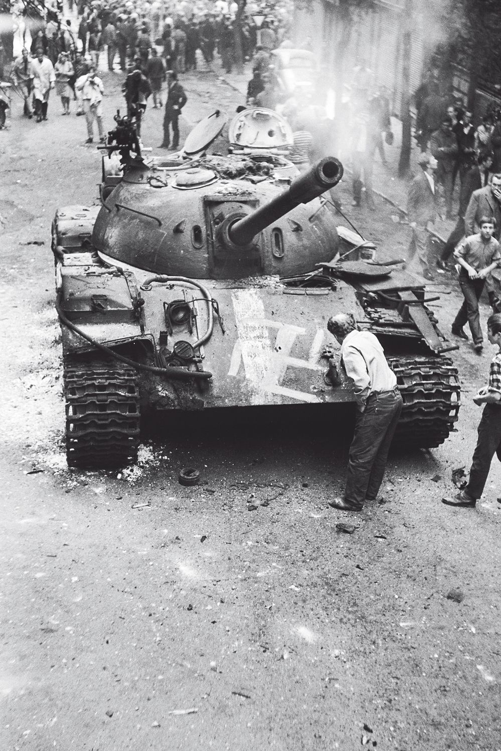 1968. Muž v Balbínově ulici maluje na tank hákový kříž.