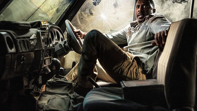 Táta Nate (Idris Elba) čeká v džípu na další útok běsnícího lva