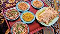 Lahodné pokrmy ománského jídla se v tradiční restauraci podávají na koberci