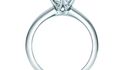 Diamant v zásnubním prstenu Tiffany Settings vyzvedává nad kroužek šest krapen
