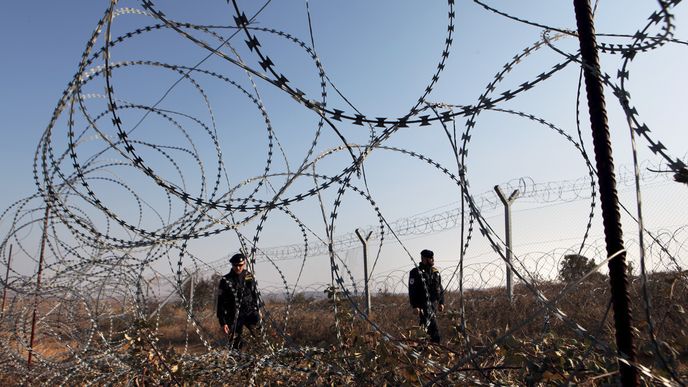 Čeští policisté kontrolují, kde je plot poničen migranty.Ti žiletkový plot prostříhávají nebo jej nadzvedávají. Plotem prolézají hlavně v noci. 