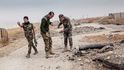 Kurdští pešmergové při odstraňování min v Bašice  nedaleko Mosulu. Červené praporky označují již nalezené miny. 