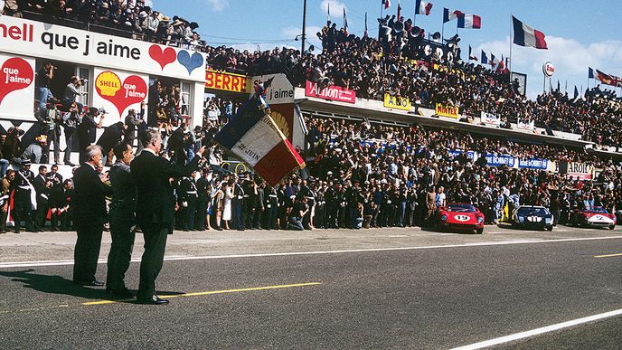 Závod 24 hodin Le Mans těsně před startem. Vpravo dva soupeřící vozy, o které v tomto příběhu jde: Ferrari 330P a Ford GT40.