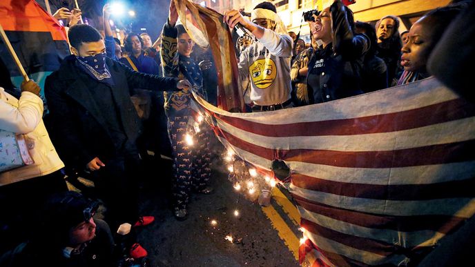 Demonstranti ve Washingtonu pálí americké vlajky poté, co velká porota odmítla obvinit policistu, který zastřelil Michaela Browna