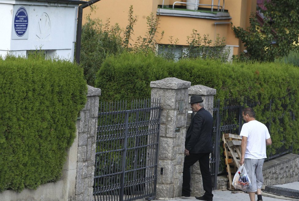 Josef Rychtář vybaven apartním klouboučkem a láhví v ruce se vrací do domu Dariny Nové.