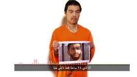 ISIS chtějí zpět svou atentátnici výměnou za jordánského pilota. Na snímku ho drží na fotce japonský vězeň Kendži Goto.