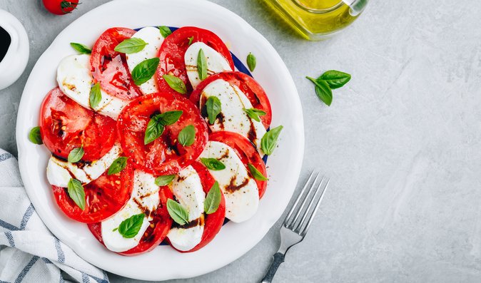 Salát Caprese z různých druhů rajčat, mozzarelly a bazalky oceníte během letních teplých dní.