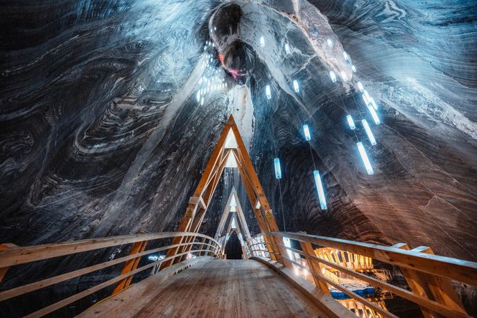 Světla v dole visí v prostoru, který je sám o sobě impozantní. Světla v dole visí v prostoru, který je sám o sobě impozantní.