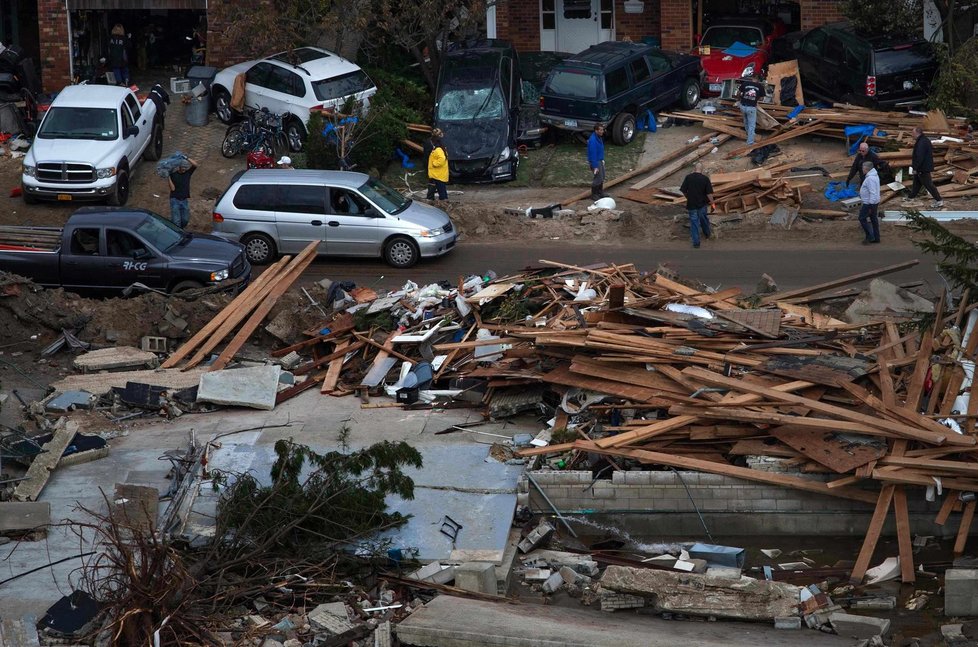 Lidé se snaží odklidit škody napáchané hurikánem Sandy, který si vyžádal už 72 obětí