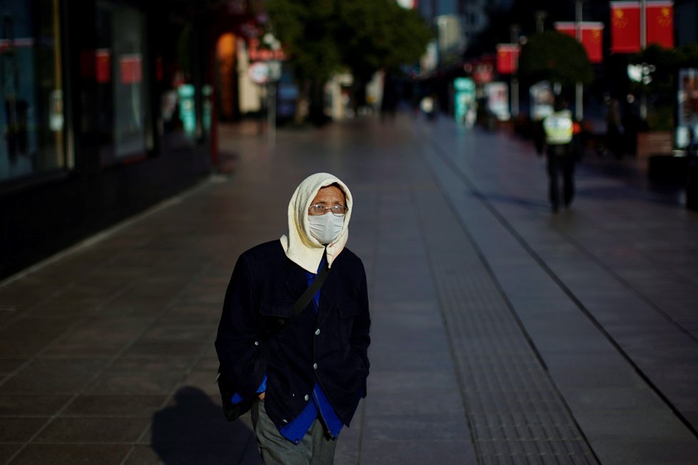 Muž s rouškou v obchodní čtvrti v Šanghaji