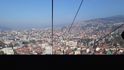 Pohled z lanovky na Sarajevo. Ta má konečnou stanici ve výšce zhruba 1100 metrů, horské štíty nad městem se ale tyčí až do 1630 metrů.