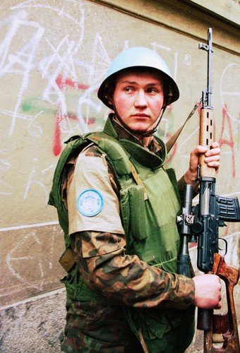 Ukrajinský voják mírových sil OSN hlídá při evakuaci uprchlíků ze Sarajeva v roce 1993.