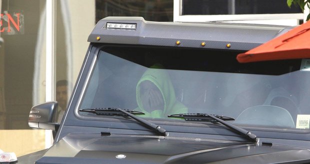 Justin Bieber sedí v autě a schovává si hlavu v dlaních