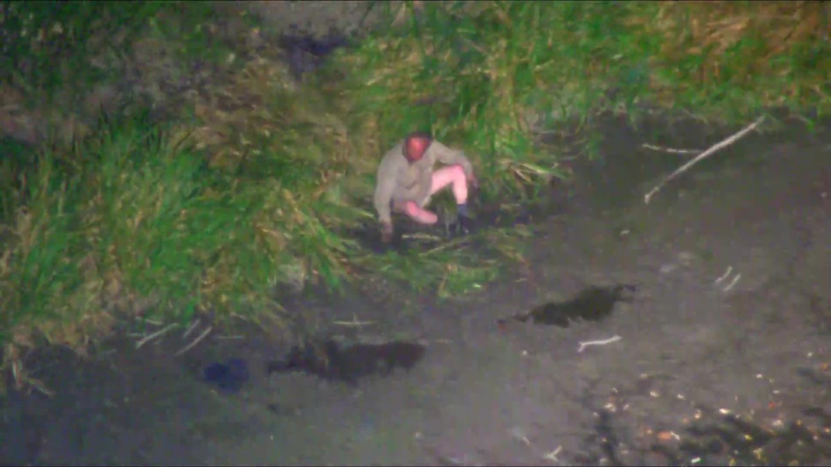 Muž seděl v bahně na okraji rybníka.