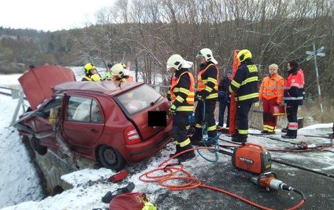 Auto po střetu zůstalo viset z mostu u trati...