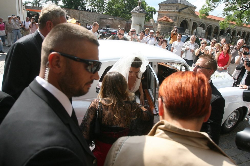 Alena Šeredová ve svatebních šatech vystupuje z limuzíny.