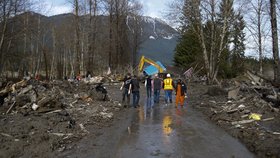 Záchranáři v americkém státě Washington se snaží vyprostit z bahna a trosek další oběti mohutného sesuvu půdy.