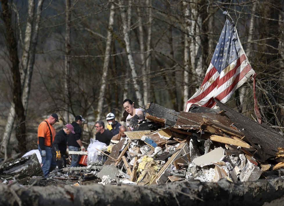 Záchranáři v americkém státě Washington se snaží vyprostit z bahna a trosek další oběti mohutného sesuvu půdy.