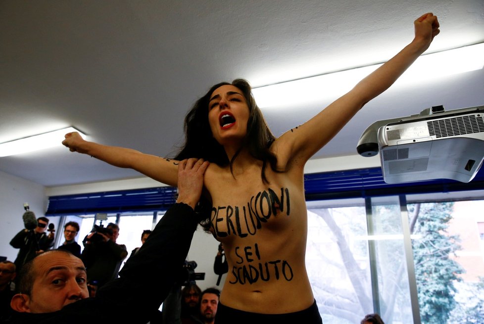 Před expremiérem Berlusconim ve volební místnosti vyskočila na stůl polonahá aktivistka hnutí Femen.