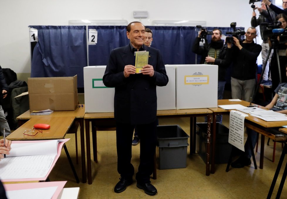 Bývalý premiér Itálie Silvio Berlusconi ve volební místnosti s volebním lístkem v rukou.