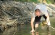Zvířecí záchranář Radek Zeman sbírá škeble ze dna přehrady.