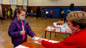 Žákyně základní školy Chabařovice na Ústecku ukazuje zdravotnici v tělocvičně školy výsledek testu na koronavirus. Vláda rozhodla, že žáci prvního stupně základních škol se od tohoto dne vrátí do lavic v rotační formě, ve školách je jen polovina žáků (12. 4. 2021).