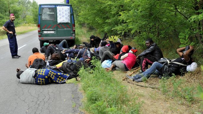 Skupina 25 běženců z Konga čeká 25. června pod dohledem policie na okraji obce Ásotthalom na srbsko-maďarské hranici na transport do uprchlického tábora.