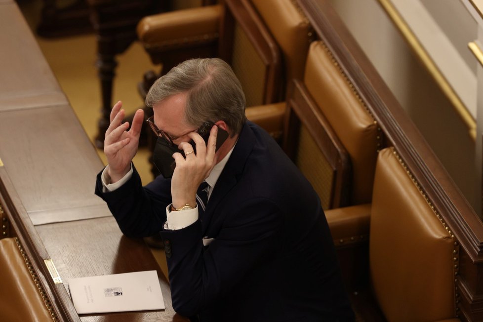 V hlavní roli telefon: Premiér Petr Fiala chodil při jednání Sněmovny o důvěře vládě často telefonovat do zadních telefonních lavic.