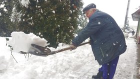 Pavel Luchava (82) odklízí sníh, přestože má problémy se zády. odhazuje ho i s nasazeným krunýřem.