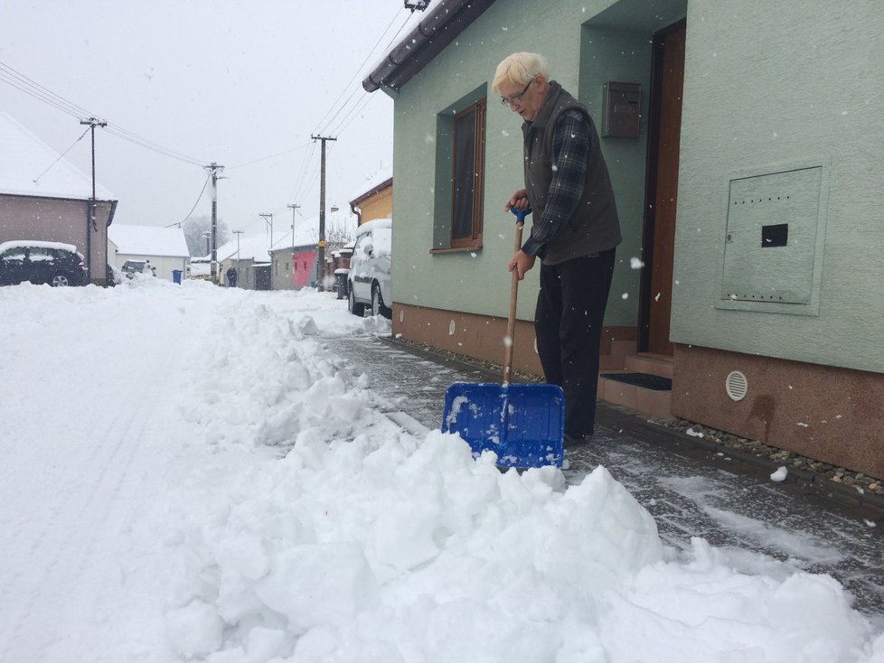 František Lovecký (68) odklízí sníh na chodníku u svého domu, jakmile ale projede auto údržby, může začít zase znovu.