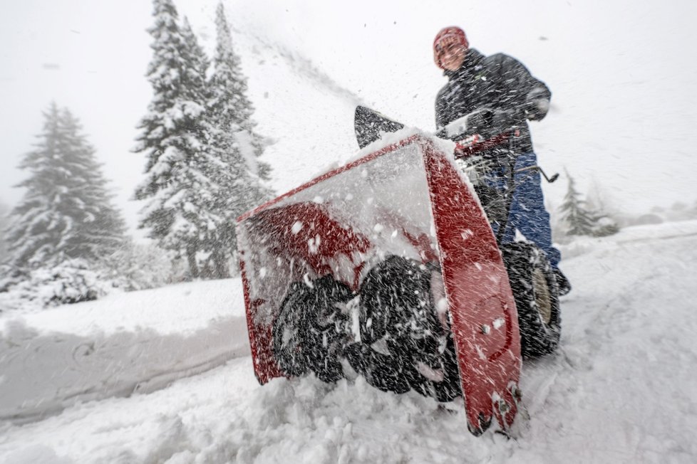 Muž odklízí čerstvý sníh frézou, Bystré, Rychnovsko (1. února 2023).