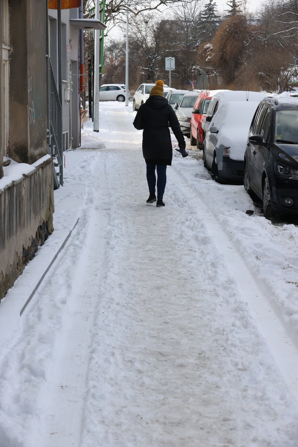 Únor 2021: Zasněžená Praha dělá problémy chodcům. 1 200 metačů se sice o chodníky stará, kvůli sněhu a námraze však kloužou dál.