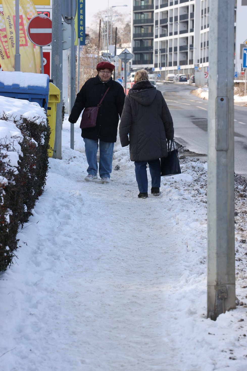 Únor 2021: Zasněžená Praha dělá problémy chodcům. 1 200 metačů se sice o chodníky stará, kvůli sněhu a námraze však kloužou dál.