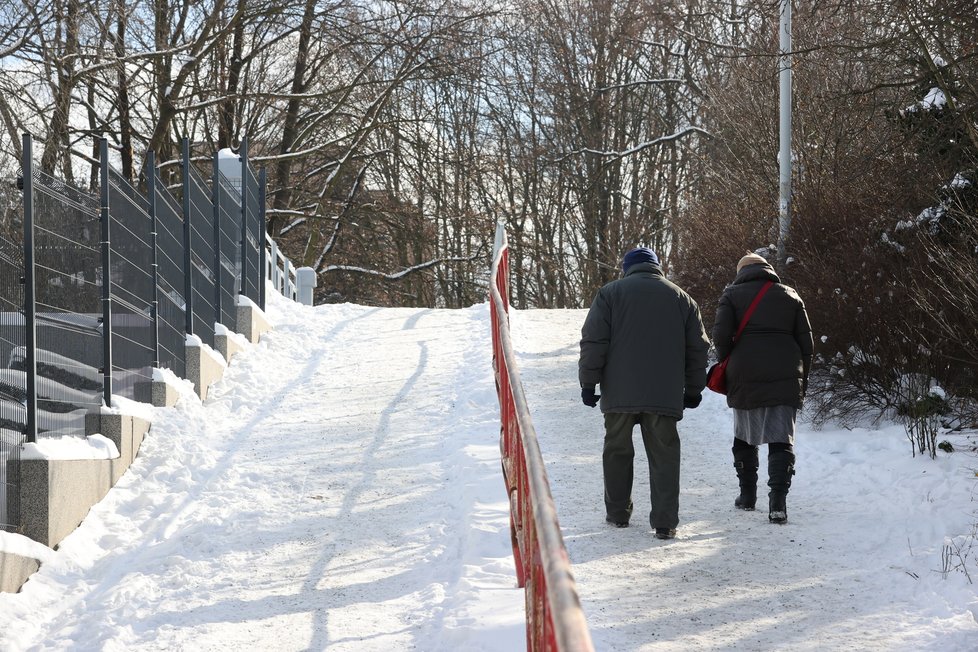 Únor 2021: Zasněžená Praha dělá problémy chodcům. 1 200 metačů se sice o chodníky stará, kvůli sněhu a námraze však kloužou dál.