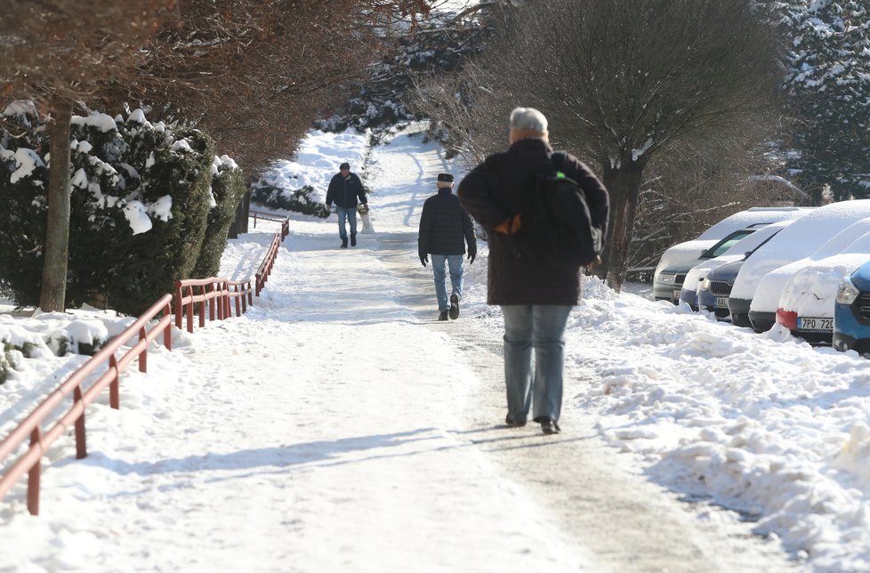 Únor 2021: Zasněžená Praha dělá problémy chodcům. 1 200 metačů se sice o chodníky stará, kvůli sněhu a námraze však kloužou dál.