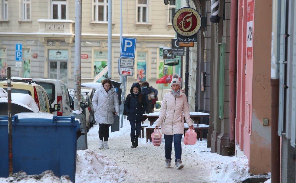 Únor 2021: Zasněžená Praha dělá problémy chodcům. 1 200 metačů se sice o chodníky stará, kvůli sněhu a námraze však kloužou dál.