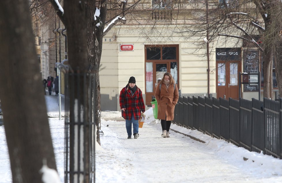 Únor 2021: Zasněžená Praha dělá problémy chodcům. 1 200 metačů se sice o chodníky stará, kvůli sněhu a námraze však kloužou dál.