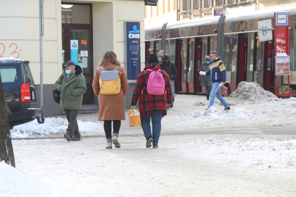 Únor 2021: Zasněžená Praha dělá problémy chodcům. 1 200 metačů se sice o chodníky stará, kvůli sněhu a námraze však kloužou dál.