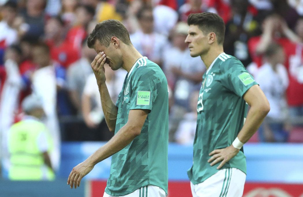 Thomas Müller možná zatlačuje slzy zklamání po prohře s Jižní Koreou a konci na MS, vpravo Mario Gomez