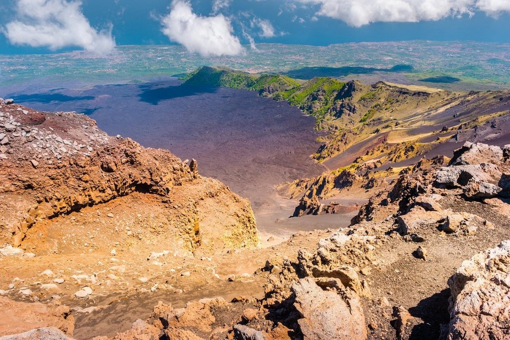 Etna, Itálie. Sicilská sopka Etna je nejvyšším a nejaktivnějším vulkánem v pevninské Evropě. Ideálním výchozím místem k návštěvě je parkoviště Rifugio Sapienza u dolní stanice lanovky. Tam můžete jednak prozkoumat dva neaktivní krátery, jednak se nechat vyvézt lanovkou výš. Dál lze pokračovat speciálními autobusy a úplně na vrchol pak pěšky. Až nahoru je nicméně možné jít pouze s místním průvodcem.