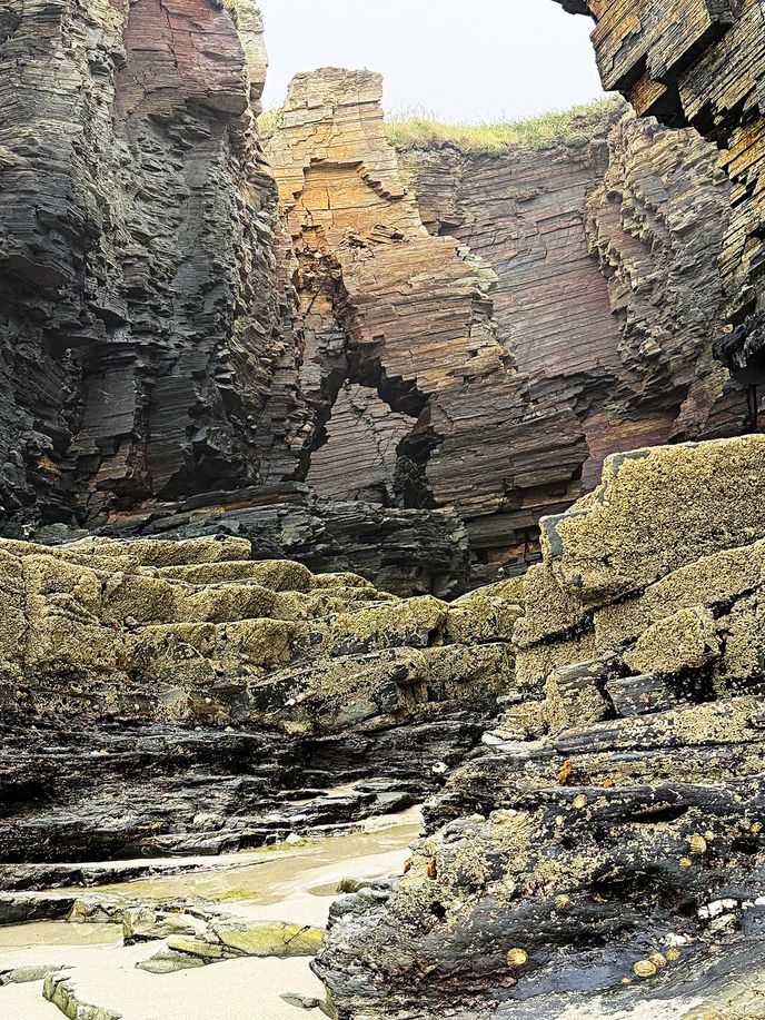 Čedičové skály se pod vlivem větru a vody lámou v geometrických blocích Čedičové skály se pod vlivem větru a vody lámou v geometrických blocích