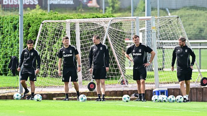 Šéftrenér Priske (uprostřed) a část jeho početné ekipy při včerejším tréninku rudých.