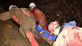 Záchranáři přenášejí zraněného k východu z jeskyně.