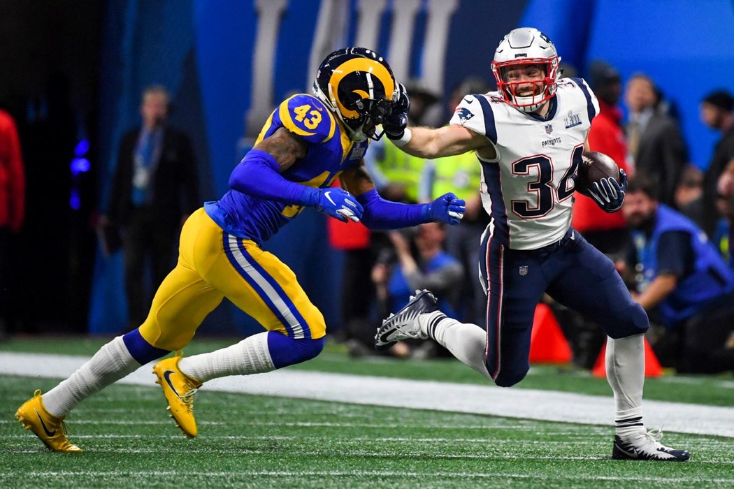Rex Burkgead z New England Patriots se snaží dostat přes safetyho Los Angeles Rams Johna Johnsona (43) během Super Bowlu LIII