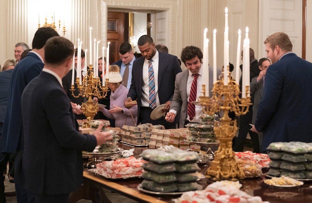 Při návštěvě Bílého domu si hráči Clemsonu Tigers mohli dopřát raut z hamburgerů a pizzy, které kvůli blokaci peněz pro federální úřady nakoupil Donald Trump ze svého