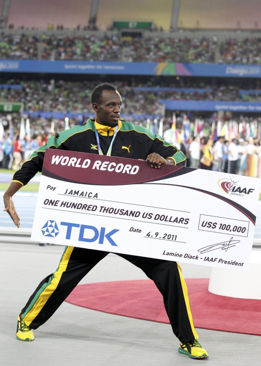 Usain Bolt pózuje s cenou pro rekordní jamajskou štafetu