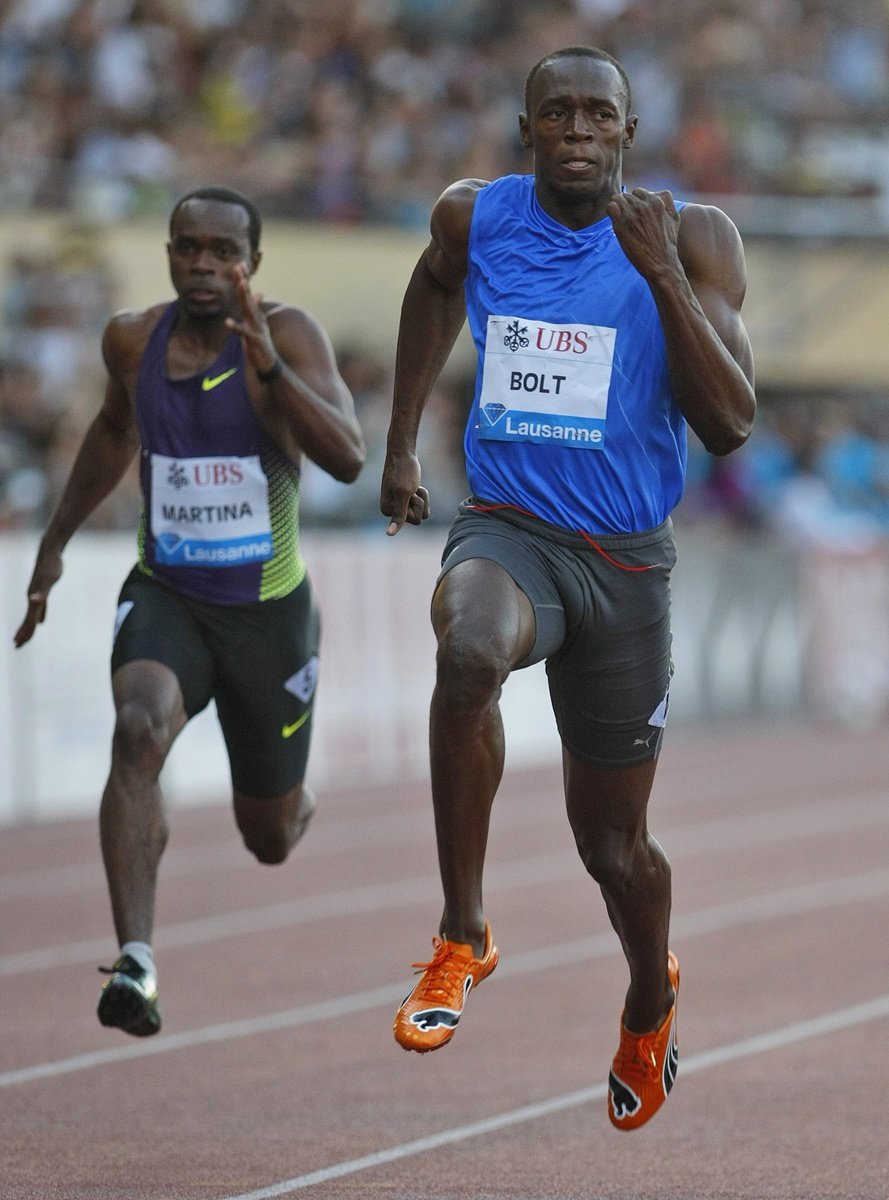 Usain Bolt protíná cílovou pásku na mítinku Diamantové ligy v Lausanne, vlevo dobíhá Churandy Martina