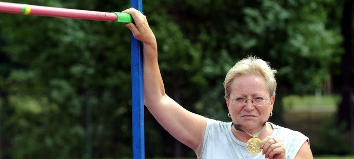Miloslava Rezková-Hübnerová ukazuje svoji zlatou olympijskou medaili a laťku ve výšce 182 centimetrů