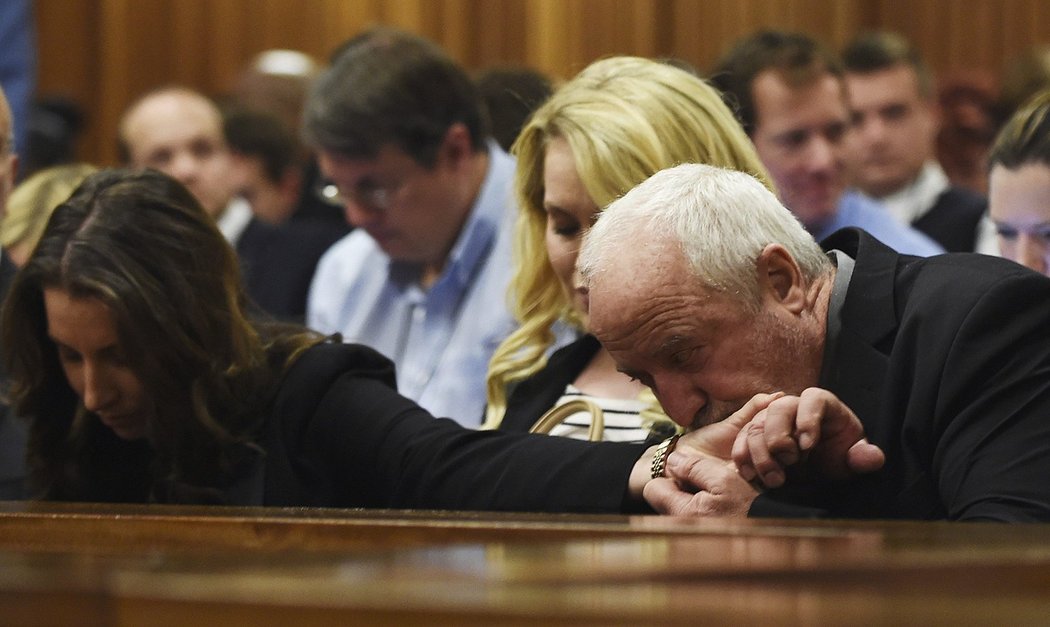 Pistoriův otec Henke líbá během předčítání rozsudku nad jeho synem ruku své dcery  Aimee