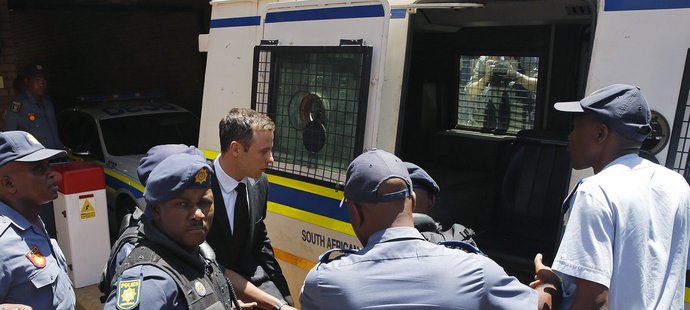 Oscar Pistorius míří do policejního auta, které ho odveze do věznice
